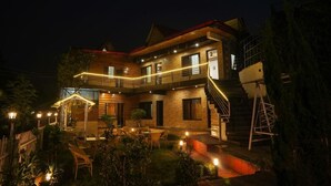 A two-story wooden house with a balcony, outdoor seating area, and a staircase. - 7 Lake Stays Sattal (India)