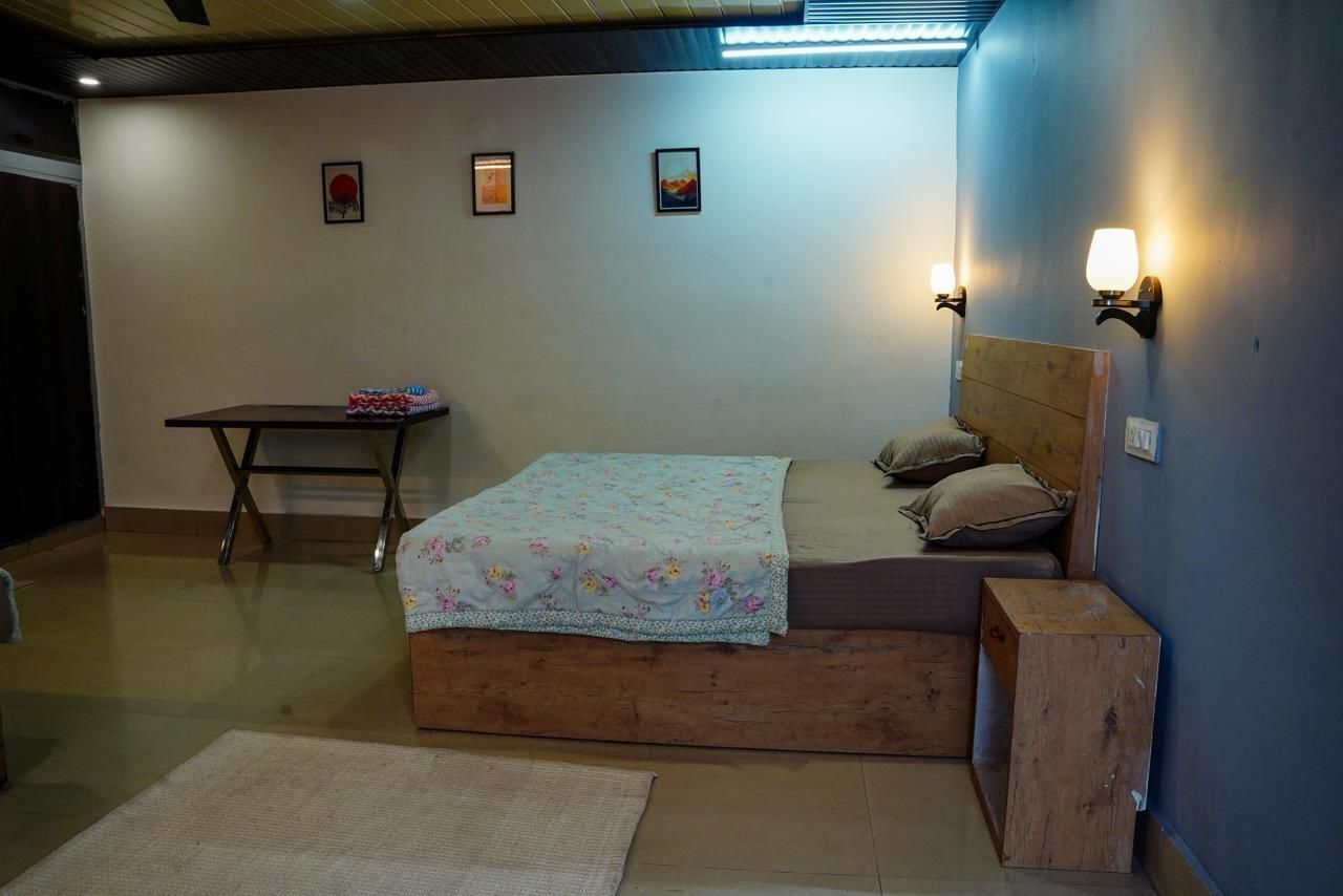 A bedroom with a bed, bedside tables, and wall-mounted lamps.