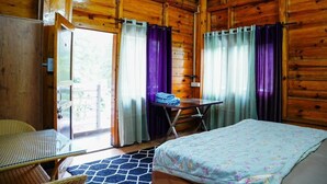 A wooden cabin room with a bed, a table, and a chair. - 7 Lake Stays Sattal (India)