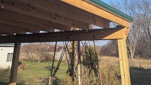 Eine Windmühle mit Holzkonstruktion und einem grünen Dach.