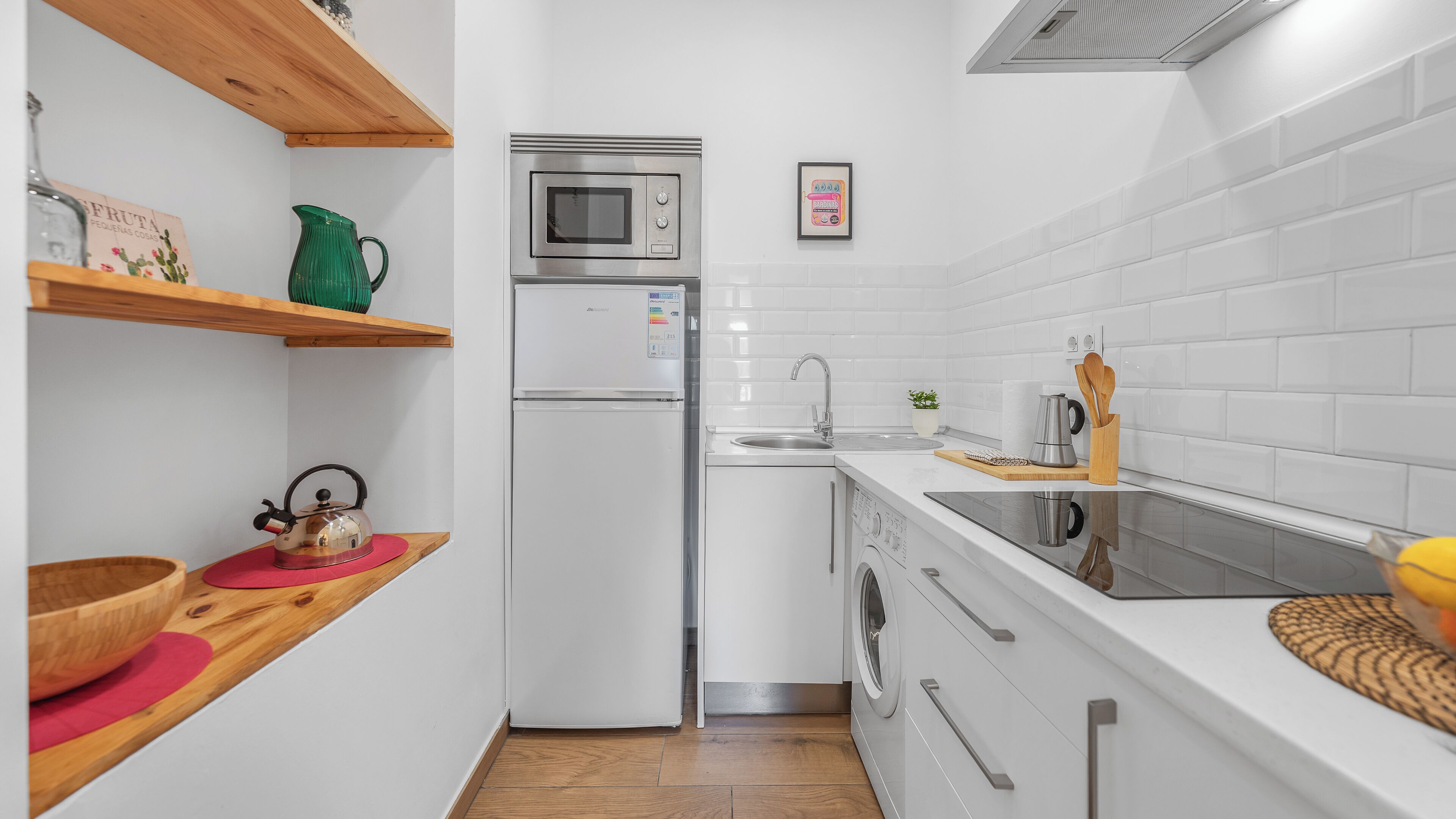 Una cocina moderna con refrigerador, microondas, pileta y estufa.