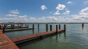 A wooden dock extending into calm water with boats docked nearby. - Great views of Marco River from 5th Floor condo (Marco Island)