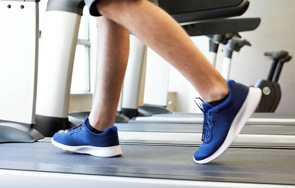 A treadmill in a gym with a person running. - Hyatt House Schenectady / Mohawk Harbor (Schenectady)