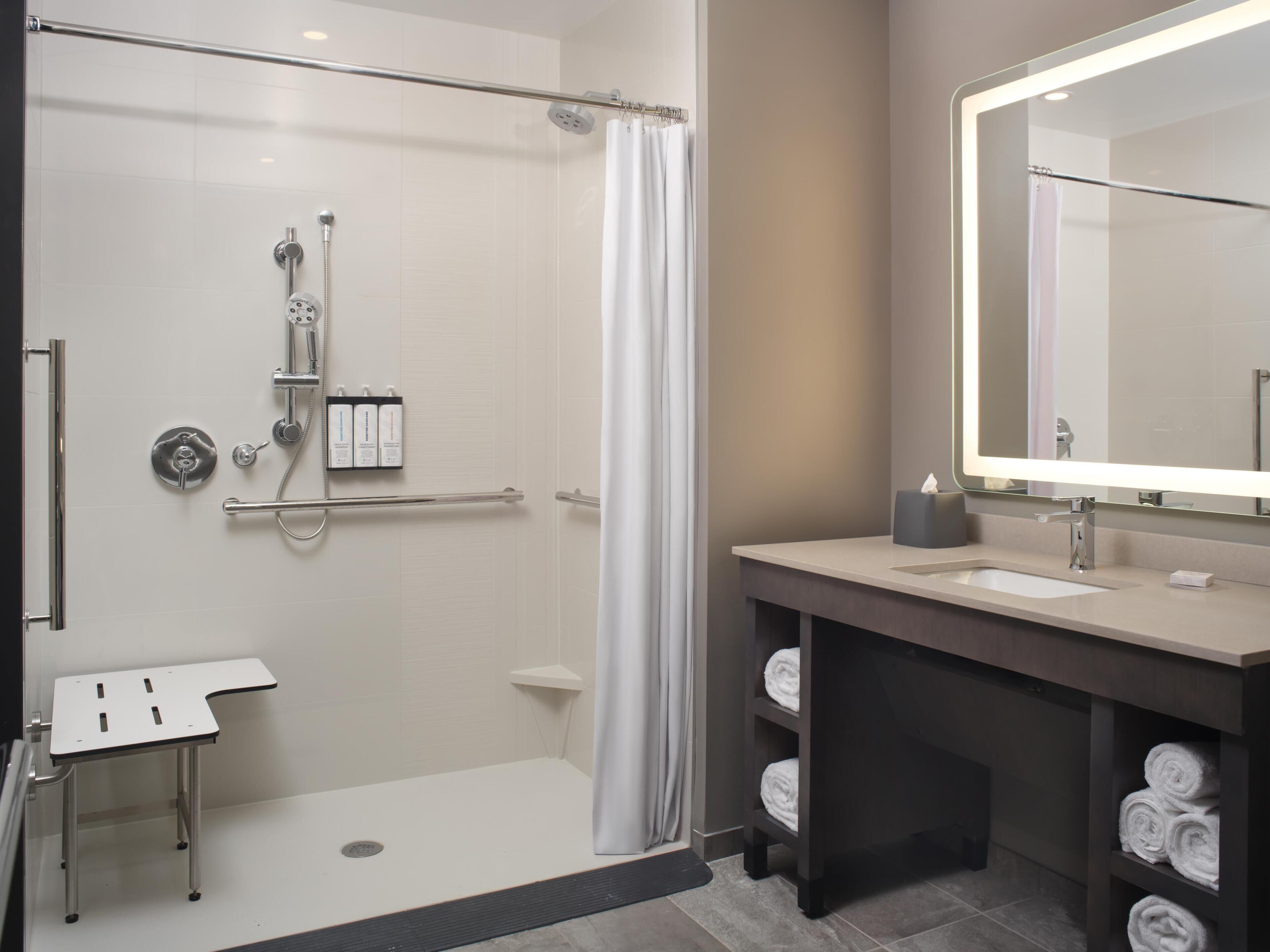 Un bagno moderno con doccia, toilette, lavandino e specchio.