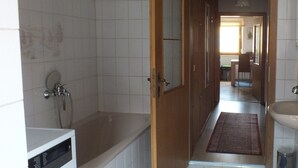 Une salle de bain avec une baignoire, un lavabo et un miroir.