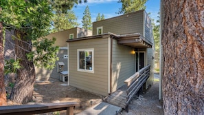 A small building with a ramp leading to a door, surrounded by trees.