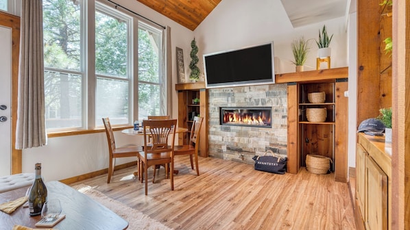 A cozy room with a fireplace, wooden furniture, and a television mounted on the wall. - Cozy Tahoe Townhome w/ Fireplace, Balcony & Quick Access to Trails & Lake Cubana - Dollar Hill by Avantstay (Tahoe City)