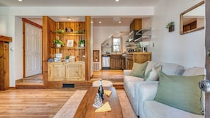 A cozy living room with a wooden reception desk, a sofa, and a dining table. - Cozy Tahoe Townhome w/ Fireplace, Balcony & Quick Access to Trails & Lake Cubana - Dollar Hill by Avantstay (Tahoe City)