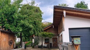 Ein rustikales Gebäude mit Kopfsteinpflaster-Einfahrt, Holzfassade und einem Schild.