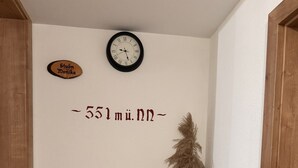 Eine Ecke mit einer Uhr, einem Schild und einer Zierpflanze.