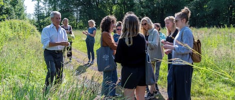 A group of people standing on a grassy path in a natural setting.