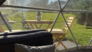 A room with a view through a large window, a wooden table, and a chair outside. - The Little Retreat (Kilgetty)