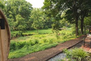 A wooden structure with a view of a lush garden and a pathway. - The Firefly Retreat in Lancaster county (Manheim)