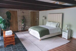 A bedroom with a bed, bedside table, lamp, and a potted plant. - The Firefly Retreat in Lancaster county (Manheim)