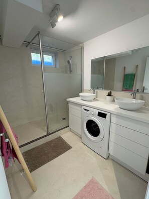 A modern bathroom with a glass shower enclosure, a washing machine, and two sinks. - A modern home with breathtaking views (La Tronche)