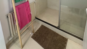 A small, modern bathroom with a glass shower enclosure, a wooden ladder, and a radiator. - Modern nest with breathtaking views (La Tronche)
