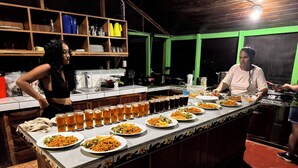 A bar area with a long counter displaying various dishes and drinks. - Sabalo lodge (Sierpe)