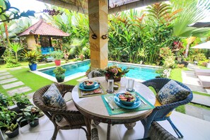 An outdoor dining area with a pool, surrounded by lush tropical plants and a small gazebo. - Brilliant 3-bedroom villa with Pool and AC in peaceful Ubud (Ubud)
