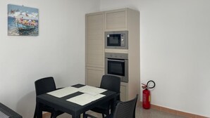 A small kitchenette with a microwave, oven, and a red fire extinguisher. - Just minutes from Ogliastra's most beautiful beaches, rooms with en suite facilities (Cardedu)