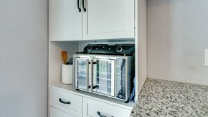 A kitchen with white cabinets, a stainless steel oven, and a granite countertop. - 10 Mi to Lake Conroe: Couple’s Retreat w/ Porch! (Montgomery)