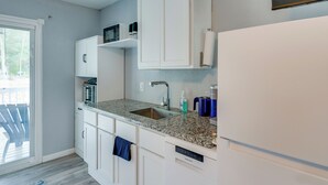 A modern kitchen with white cabinetry, a granite countertop, a stainless steel sink, and a built-in microwave. - 10 Mi to Lake Conroe: Couple’s Retreat w/ Porch! (Montgomery)