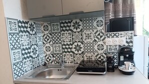 Cuina amb un vàter d'acer inoxidable, una cafetera Bosch i una màquina de cafè Valberg.