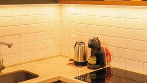 Een keuken met een magnetron, koffiezetapparaat en vaatwasser.