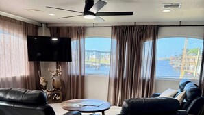 A modern living room with leather sofas, a wooden coffee table, and a flat-screen TV. - Waterfront 3-bedroom private dock for boat access in Corpus Christi (Corpus Christi)
