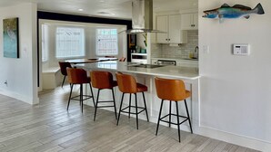 A modern kitchen with a central island, bar stools, and a fish decoration on the wall. - Waterfront 3-bedroom private dock for boat access in Corpus Christi (Corpus Christi)
