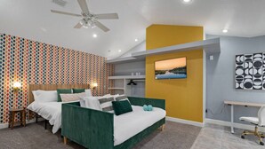 A modern hotel room with a large bed, a desk, and a ceiling fan. - Sunny Auburndale Retreat w/ Pool (Auburndale)