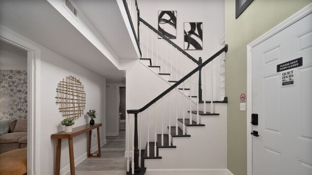 A staircase with black railings and white steps, leading to a door with a 'Quiet Hours' sign.