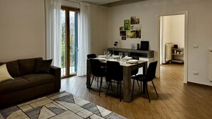 Ein modernes Wohnzimmer mit Essbereich, einer Couch und Blick ins Freie.