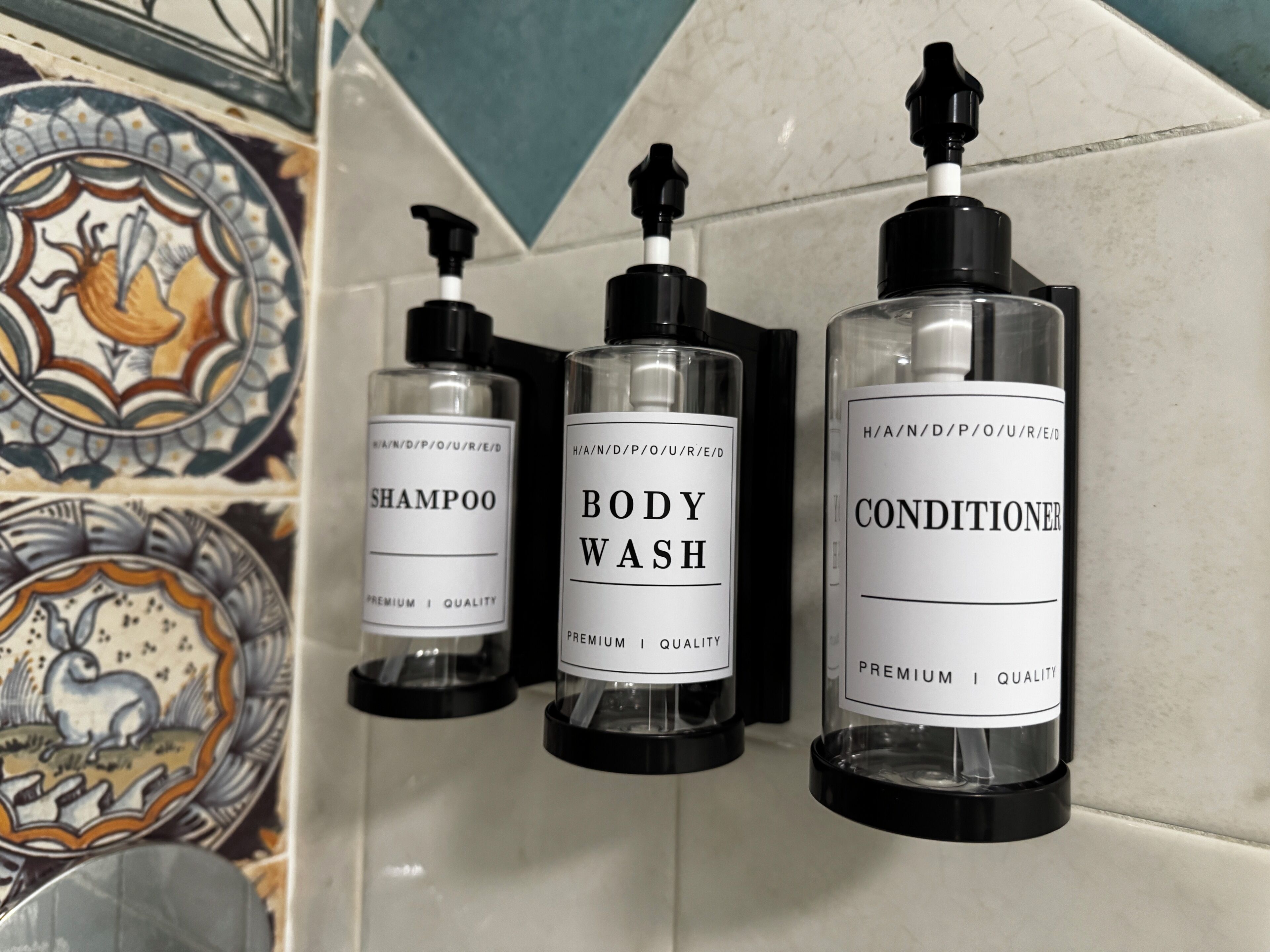 Trois flacons de produits d’hygiène personnelle sont posés sur un mur carrelé.