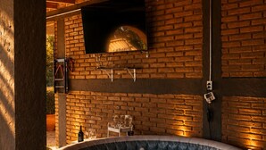 Un jacuzzi en una habitación con paredes de ladrillo y vigas de madera.