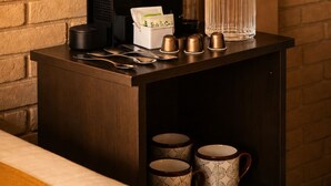Una estación de café con cafetera, dispensador de agua y un perchero para tazas.