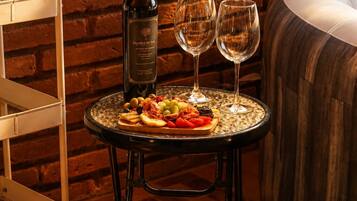 Una mesa con una botella de vino, dos copas y un plato de comida.