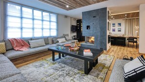 Ein modernes Wohnzimmer mit einem Ecksofa, einem Couchtisch und einem Kamin.