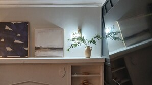 A room with a fireplace, shelves with decorative items, and a wall-mounted TV. - Private Romantic Retreat for Two • Luxury Escape (Chicago)