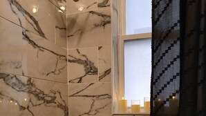 A bathroom with a bathtub, a showerhead, and a window with a view. - Private Romantic Retreat for Two • Luxury Escape (Chicago)