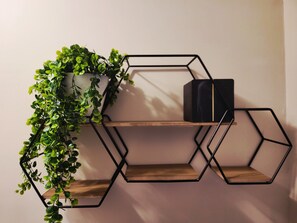 A hexagonal metal shelf unit with a potted plant on the left and a black box on the right. - Private Romantic Retreat for Two • Luxury Escape (Chicago)