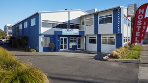 A two-story building with a sign reading "Pacific Coast Lodge." - Pacific Coast Lodge and Backpackers (Tauranga)