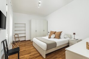 A modern bedroom with a bed, nightstands, a TV, and a wardrobe. - Atrhome- Penthouse Tritone (Rome)