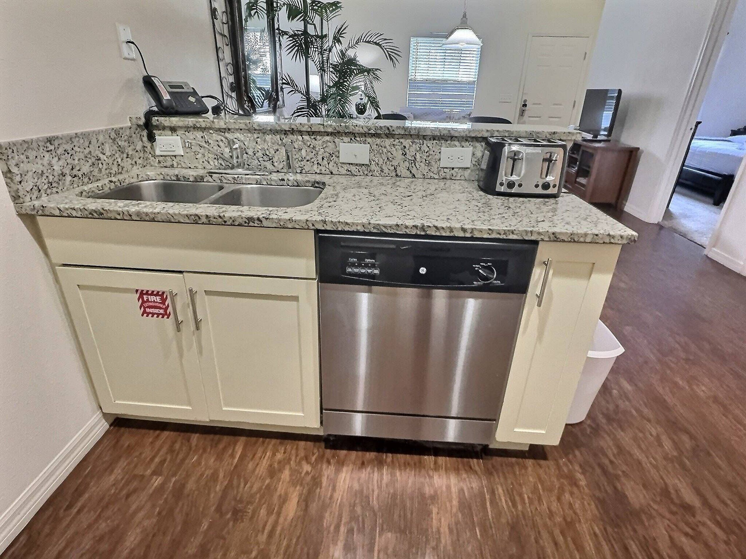 A kitchen with granite countertops, stainless steel appliances, and a dishwasher.