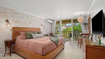 A bedroom with a wooden bed, a small table, and a TV.