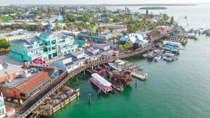 A waterfront hotel with multiple buildings, a dock, and boats. - Intracoastal house w/Boat Lift in Treasure Island (Treasure Island)