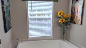 A bathroom with a large bathtub, a window with blinds, and a painting on the wall. -  Beautiful piece of property in Westpoint. Great location for NATRA enthusiasts. (Westpoint)