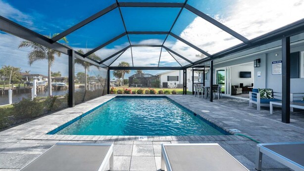Ein überdachter Pool mit freiem Blick auf die Umgebung, darunter eine Bootsanlegestelle und ein Gebäude mit Außenbereich.