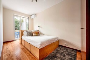 Une chambre à coucher avec un lit en bois, une fenêtre et une porte.