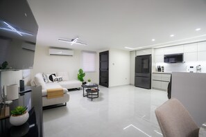 A modern apartment with a living area, kitchen, and a small dining space. - Modern Cozy Apt Just Steps from the Beach (Crolina)