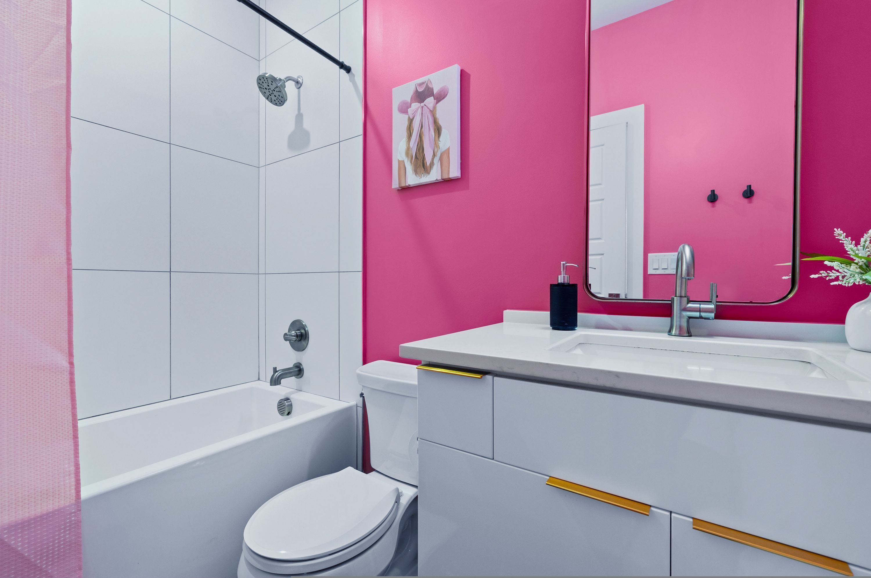 A bathroom with a white bathtub, a toilet, and a sink with a mirror.